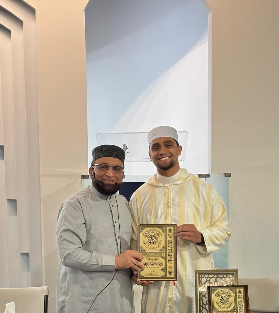 Dr. Shaykh Mamdouh conferring an ornately bound Qurʾan on a graduate.